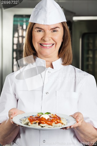 Image of Cheerful Chef Presenting Dish