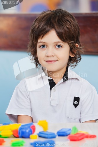 Image of Cute Boy With Blocks On Desk At Kindergarten