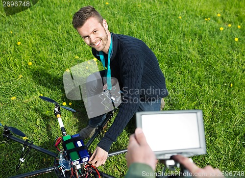 Image of Engineer Fixing UAV Helicopter in Park