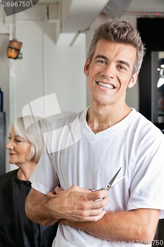 Image of Hairstylist Holding Scissors In Salon