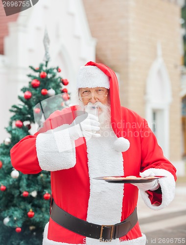 Image of Santa Claus With Cookies Drinking Milk