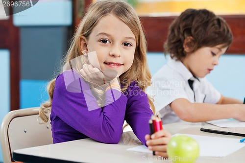 Image of Girl Holding Color Pencils With Friend Drawing In Background