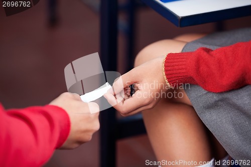 Image of Schoolchildren Passing Cheat Sheet