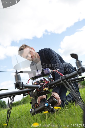 Image of Engineer Fixing Camera On UAV Helicopter