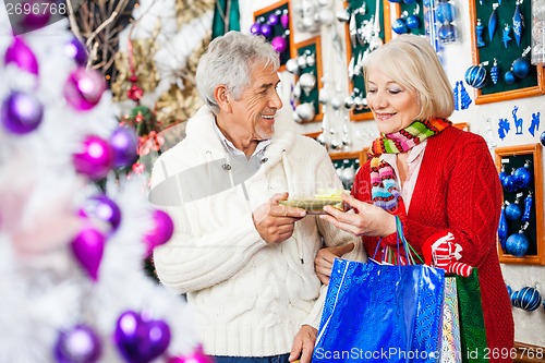 Image of Couple Holding Present At Christmas Store