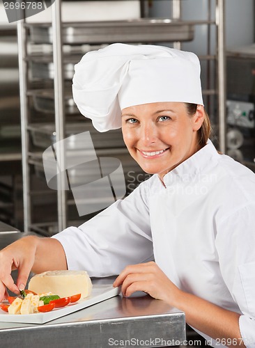 Image of Happy Female Chef Garnishing Dish