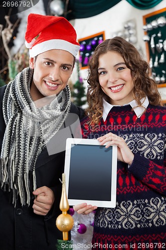 Image of Happy Couple Showing Digital Tablet At Christmas Store