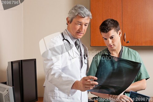 Image of Doctor And Technician Reviewing X-ray