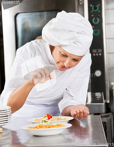 Image of Chef Adding Spices To Dish