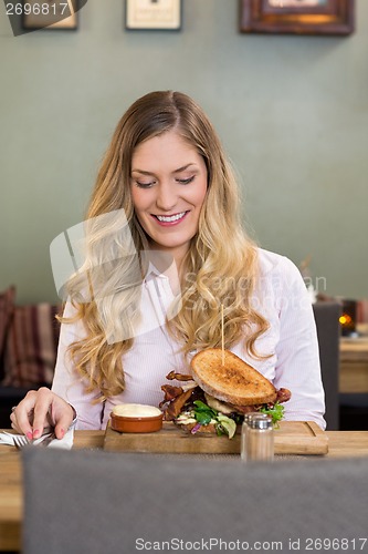 Image of Young Woman Looking At Burger