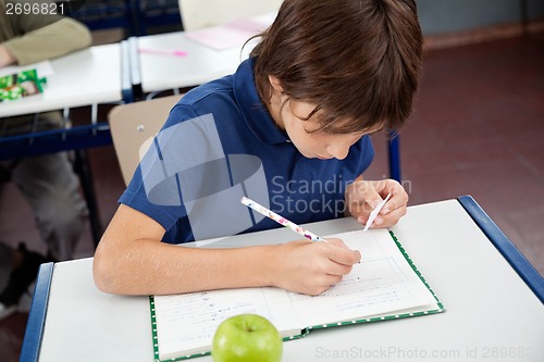 Image of Schoolboy Copying From Cheat Sheet During Examination