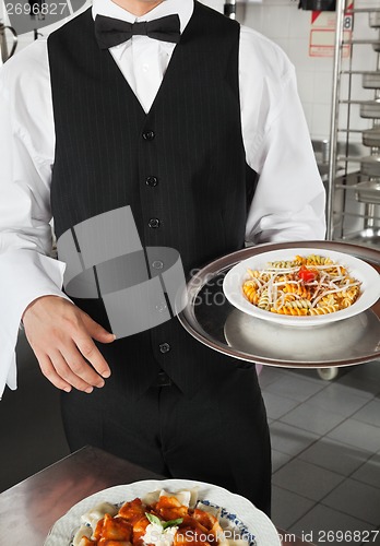 Image of Waiter Holding Dish In Kitchen