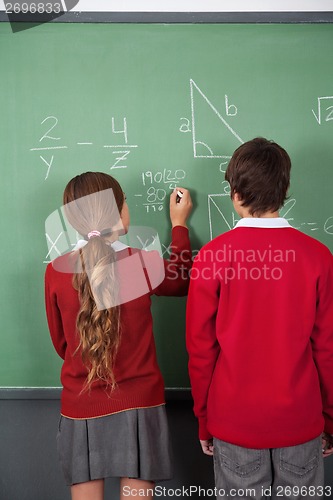 Image of Teenage Students Solving Mathematics On Board