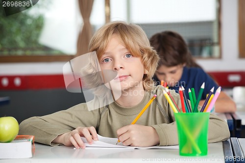Image of Portrait Of Schoolboy Writing In Book At Desk