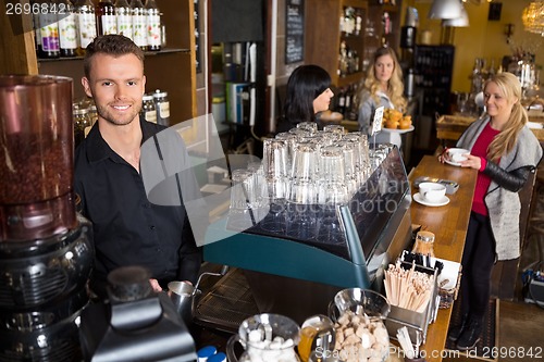 Image of Male Bartender With Colleague Working In Background