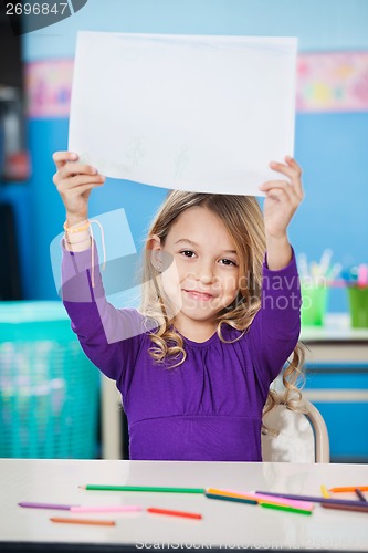 Image of Girl Showing Blank Paper At Desk