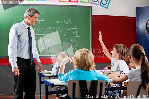Image of Professor Looking At Schoolboy Raising Hand