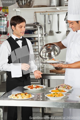 Image of Chef Giving Customer's Food To Waiter