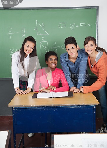 Image of Teacher With Teenage Students At Desk In Classroom