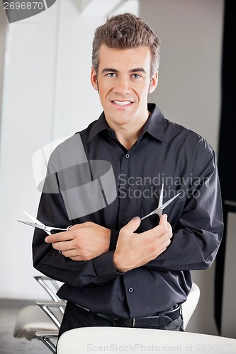 Image of Confident Hairstylist Holding Two Scissors