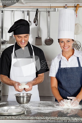 Image of Chefs Kneading Dough In Kitchen