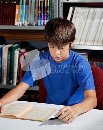 Image of Teenage Schoolboy Reading Book In Library