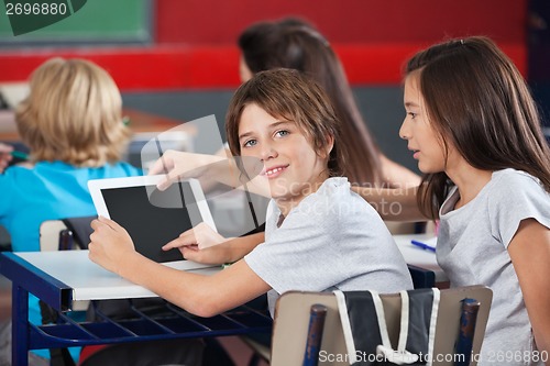 Image of Boy With Girl Using Digital Tablet At Desk