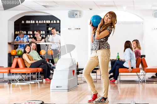 Image of Woman Holding Bowling Ball in Club