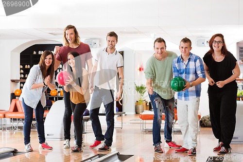 Image of Man And Woman Bowling With Friends in Club