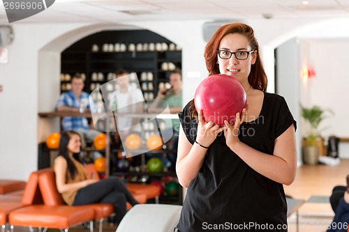 Image of Young Woman Bowling in Club