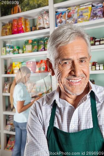 Image of Owner With Female Customer Shopping In Background