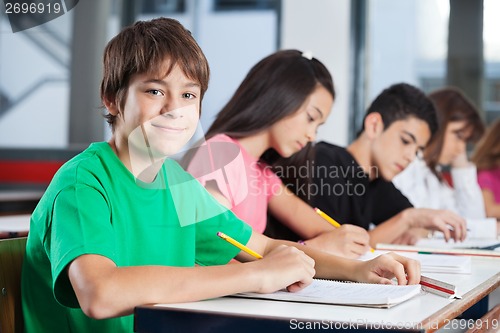 Image of Teenage Boy With Friends Studying At Desk