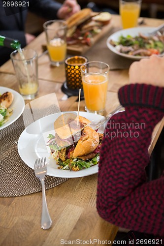 Image of Young Woman With Burger In Plate
