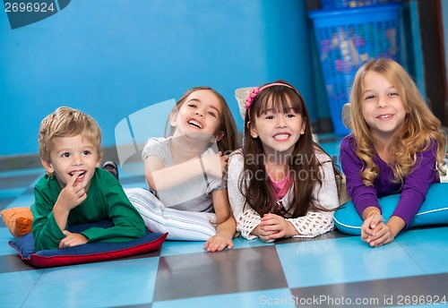 Image of Children Lying In A Row On Floor In Kindergarten