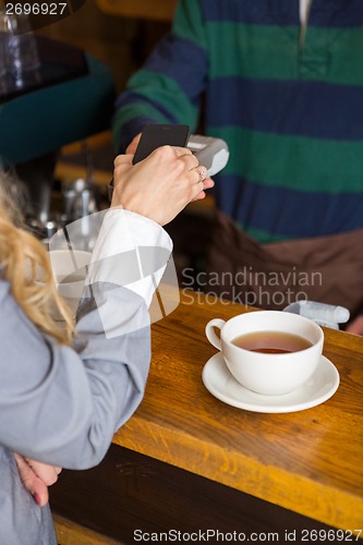 Image of Woman Making Payment Through Mobilephone