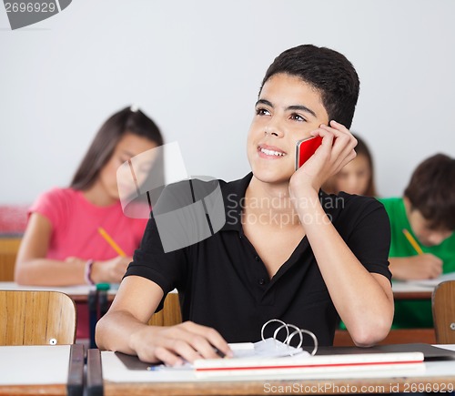 Image of Male Student Using Cellphone In Classroom