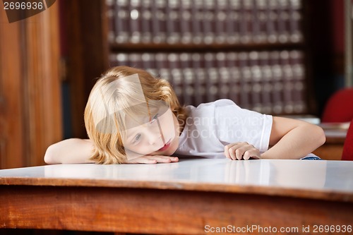 Image of Thoughtful Schoolboy Leaning On Table In Library