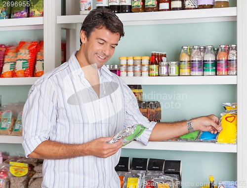 Image of Man Selecting Food Packets In Store