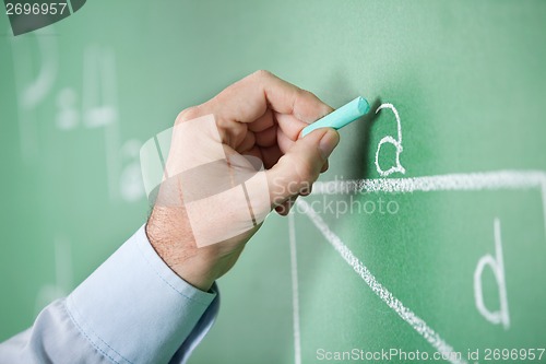 Image of Mature Teacher'S Hand Writing Alphabet On Greenboard
