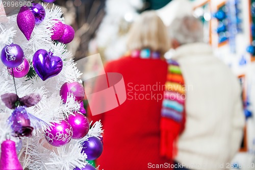 Image of Decorated Christmas Tree And Couple In Store