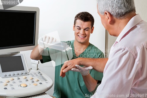 Image of Technician Putting Gel On Patient's Hand