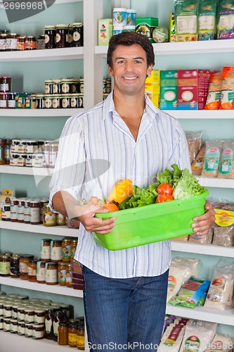 Image of Man Holding Basket Of Vegetables In Supermarket