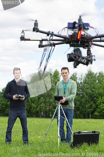 Image of Technicians Flying UAV Helicopter in Park