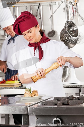Image of Female Chef Seasoning Salmon Roll
