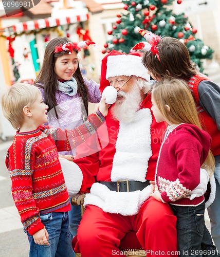 Image of Friends Playing With Santa Claus