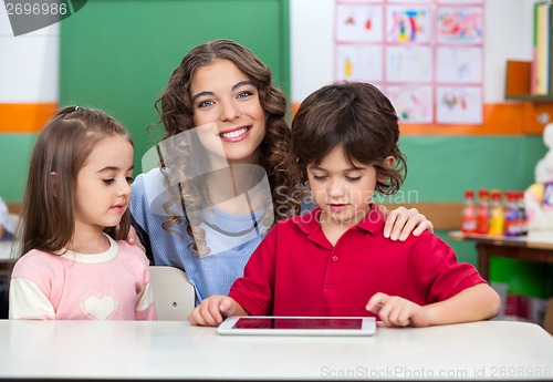 Image of Teacher With Children Using Digital Tablet At Desk