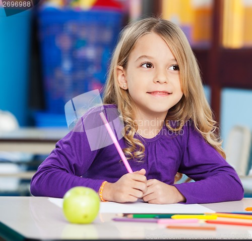 Image of Thoughtful Girl With Sketch Pen And Paper In Classroom