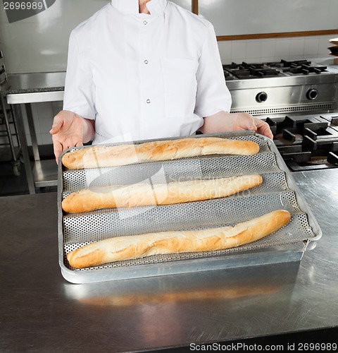 Image of Female Chef Presenting Loafs In Kitchen