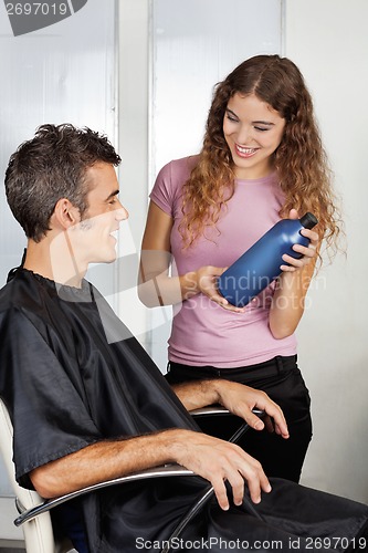 Image of Hairdresser Presenting Shampoo Bottle To The Client