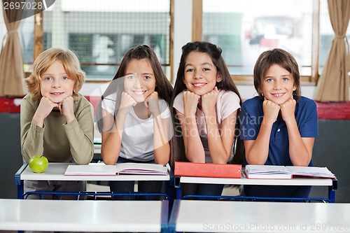 Image of Schoolchildren Leaning At Desk Together